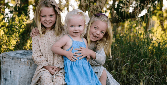 Portrait of Dr. Mickle’s three daughters smiling outdoors