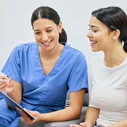 Dental team member and patient looking at clipboard