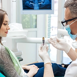 A dentist discussing the possibility of dental implants with a patient during a consultation