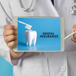 Dentist holding tablet that reads Dental Insurance