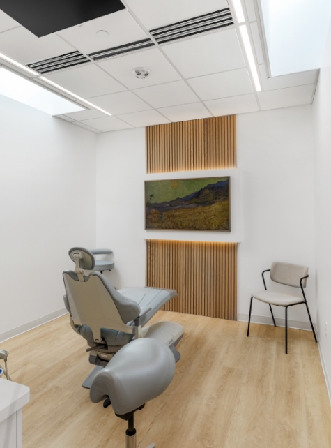 Emergency dentist standing over patient performing treatment