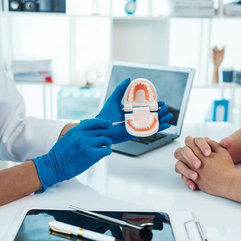 Dentist and patient talking while sitting at desk