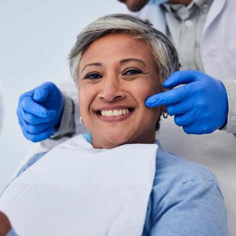 lady smiling in dental chair with denteist 