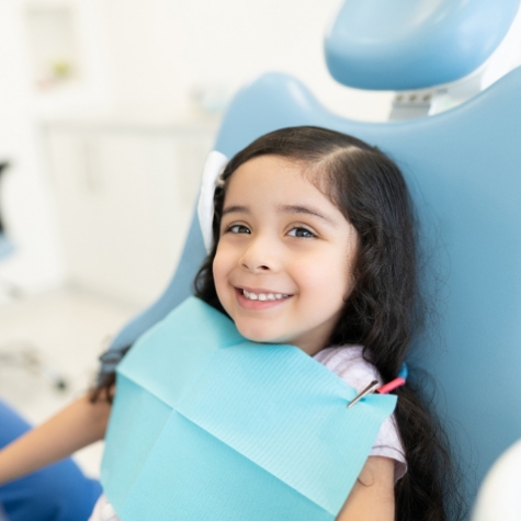 Happy young girl in dental treatment chair