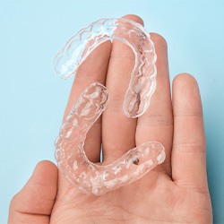 Two clear aligners resting on person’s hand