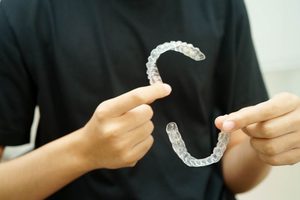 Dental professional holding two Invisalign aligners
